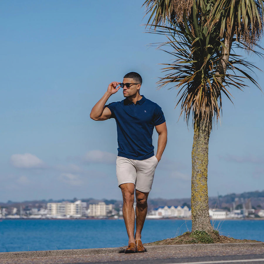 Beach side outfit. Man in Navy Polo paired with 365 shorts in Sand. True Muscle Fit Clothing. How I designed the perfect shorts.